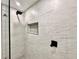 Modern bathroom shower featuring a black rain shower head, tiled walls, and built-in niche at 1968 Pleasant Hill Rd, Kissimmee, FL 34746