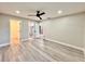Spacious bedroom featuring sleek modern flooring, ceiling fan, and access to an en-suite bathroom with glass enclosed shower at 1968 Pleasant Hill Rd, Kissimmee, FL 34746