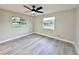 Bright bedroom featuring a ceiling fan, two windows and hard surface floors at 1968 Pleasant Hill Rd, Kissimmee, FL 34746