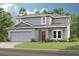 Charming two-story home featuring a two-car garage, gray siding, and a well-manicured lawn at 2038 Babbling Brook Blvd, Auburndale, FL 33823