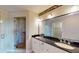 Bright bathroom with double sinks, a granite countertop, modern fixtures and a tiled walk-in shower at 2305 Edgewater Dr # 1606, Orlando, FL 32804