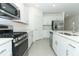 Modern kitchen featuring white cabinets, stainless steel appliances, and a central island with seating at 2559 Driftwood St, Auburndale, FL 33823