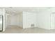 Open-concept living area with neutral tile flooring, white walls, and ample natural light from the doorway at 2559 Driftwood St, Auburndale, FL 33823