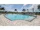 A view of a swimming pool with a depth marker, surrounded by lounge chairs and lush landscaping under a bright, sunny sky at 2559 Driftwood St, Auburndale, FL 33823
