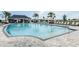 Community pool surrounded by lounge chairs, umbrellas, a pool house and landscaping provides a relaxing and inviting atmosphere at 2559 Driftwood St, Auburndale, FL 33823