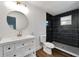 Modern bathroom featuring a vanity with drawers, white toilet, and a sleek black-tiled shower with glass at 800 N Church Ave, Mulberry, FL 33860