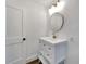 Bright bathroom featuring a vanity with drawers, round mirror, and gold light fixture at 800 N Church Ave, Mulberry, FL 33860