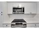 Close up of modern kitchen featuring stainless steel microwave, electric stove top and white subway tile backsplash at 800 N Church Ave, Mulberry, FL 33860