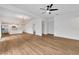 Open-concept living area featuring light wood floors, white walls, ceiling fan, and a view of the kitchen at 800 N Church Ave, Mulberry, FL 33860