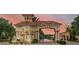 Elegant community entrance with manicured landscaping and architectural details under a beautiful sky at 1758 Coriander Dr # 1758, Poinciana, FL 34759