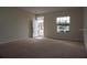 Bright, carpeted living room with a large window, offering a welcoming entrance at 1758 Coriander Dr # 1758, Poinciana, FL 34759