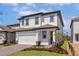 Two-story home showcasing a two-car garage, stone accents, and landscaped yard at 7712 Somersworth Dr, Kissimmee, FL 34747