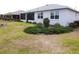 Well-maintained backyard with lush greenery, complemented by the home's exterior and screened-in lanai at 8890 Sw 104Th Cir, Ocala, FL 34481
