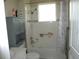 Bathroom featuring shower-tub combo with grey cabinet and a window for natural light at 8890 Sw 104Th Cir, Ocala, FL 34481