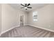 Cozy bedroom featuring a ceiling fan, plush carpeting, a window, and an attached bathroom at 7692 Somersworth Dr, Kissimmee, FL 34747