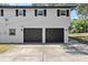 Two-car garage with black doors and ample parking space in front of a well-maintained home at 1352 Charlotte St, Altamonte Springs, FL 32701