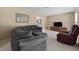 Comfortable living room with plush gray sectional sofa and burgundy armchair, perfect for relaxation at 1352 Charlotte St, Altamonte Springs, FL 32701