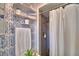 Close-up shot of bathroom area; blue wallpaper complements a shower area with toiletry storage at 53 Paine Dr, Winter Haven, FL 33884