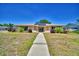 Charming single-story home featuring a tile roof, solar panels, manicured landscaping, and a paved walkway to the entrance at 53 Paine Dr, Winter Haven, FL 33884