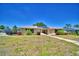 Inviting single-story home with a manicured front lawn, beautiful landscaping, and solar panels for energy efficiency at 53 Paine Dr, Winter Haven, FL 33884