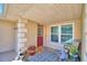 Charming front porch with a red door, inviting decor, plants, and outdoor seating at 53 Paine Dr, Winter Haven, FL 33884