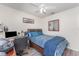 Cozy bedroom with ceiling fan, wood-look floors, and a comfortable bed and desk area at 947 Serchio St, Haines City, FL 33844