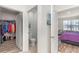 Hallway leads to a walk-in closet, half bath, and bedroom with wood floors and ample natural light at 947 Serchio St, Haines City, FL 33844