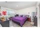 Comfortable bedroom featuring a purple comforter set, wood-look floors, and plenty of natural light at 947 Serchio St, Haines City, FL 33844