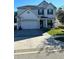 Charming two-story home with manicured lawn, paved driveway, and attached two car garage at 2121 Amor Way, Leesburg, FL 34748