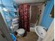 Bathroom with floral shower curtain, blue walls, wood-look flooring and a pedestal sink at 1529 Indiana St, Orlando, FL 32805