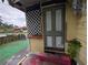 A front porch with peeling paint, exposed brick steps, and an overgrown garden at 1529 Indiana St, Orlando, FL 32805