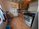 Galley kitchen featuring stainless steel appliances, wood laminate flooring, and modern backsplash at 1529 Indiana St, Orlando, FL 32805