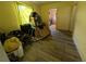 A yellow living room cluttered with luggage, hoses, clothing and other personal items at 1529 Indiana St, Orlando, FL 32805