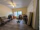 A living room with a desk, chairs, bicycles, and a mattress against the wall at 1529 Indiana St, Orlando, FL 32805