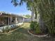 Landscaped back yard featuring mature trees and vinyl fence at 3446 Country Manor Dr, Port Orange, FL 32129