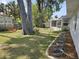Back yard with privacy fence, mature trees, and landscaped flower beds at 3446 Country Manor Dr, Port Orange, FL 32129