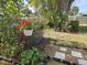 Secluded backyard features lush foliage, potted plants, and a wrought iron bench at 3446 Country Manor Dr, Port Orange, FL 32129