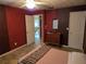 Cozy bedroom with a red accent wall, dresser, and doorway to another room at 3446 Country Manor Dr, Port Orange, FL 32129