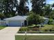 Well-maintained home featuring a charming front yard and a freshly painted white exterior with an attached garage at 3446 Country Manor Dr, Port Orange, FL 32129