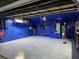 Spacious blue garage with an epoxy floor, painted walls and ceiling with installed water heater and storage shelves at 3446 Country Manor Dr, Port Orange, FL 32129