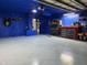 Bright blue garage with work bench and installed water heater and organized rolling storage rack at 3446 Country Manor Dr, Port Orange, FL 32129