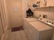 Bright laundry room featuring a white washer and dryer, a door and practical shelf with cleaning supplies at 3446 Country Manor Dr, Port Orange, FL 32129