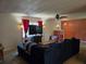 Living room with blue sofa, tile floor, large television, ceiling fan, and red curtains at 3446 Country Manor Dr, Port Orange, FL 32129