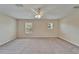 Bright bedroom featuring plush carpeting, a ceiling fan, and ample natural light from two windows at 2415 Brownwood Dr, Mulberry, FL 33860