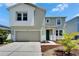 Two-story home boasts an attached two-car garage, front lawn, and well-manicured garden at 2415 Brownwood Dr, Mulberry, FL 33860