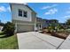 Two-story home boasts an attached two-car garage, front lawn, and well-manicured garden with mature landscaping at 2415 Brownwood Dr, Mulberry, FL 33860