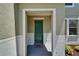 Home exterior featuring a welcoming front porch with a painted green door and neutral tones at 2415 Brownwood Dr, Mulberry, FL 33860