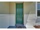 Home exterior featuring a welcoming front porch with a painted green door, neutral tones and tile flooring at 2415 Brownwood Dr, Mulberry, FL 33860