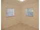 An empty room with white walls, a tile floor and two windows at 3601 Ne 24Th Ct, Ocala, FL 34479