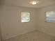 An empty room with white walls, a tile floor and two windows at 3601 Ne 24Th Ct, Ocala, FL 34479